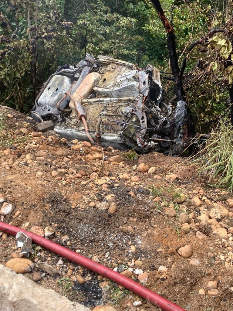 Mulher morre e homem fica gravemente ferido após carro bater em caminhão, capotar e pegar fogo na BR-153